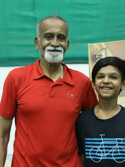 A promising 14-year-old player with his mentor. We believe in nurturing young talent with guidance from experienced figures in the sport.