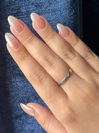 A simple yet stunning pearl chrome finish on long, natural almond-shaped nails.