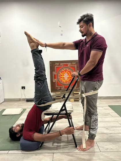 This is not just a yoga pose; it is a therapeutic intervention. Using props like a chair and belts in Sarvangasana (shoulder stand) provides stability, ensures correct alignment, and allows the body to receive the full benefits of the inversion without strain on the neck.