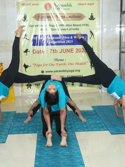An incredible display of strength and balance in a group yogasana pose, with performers supporting each other in a handstand variation.