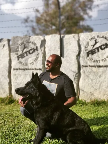 A moment with my black German Shepherd in front of my training school's motto: "Stop the blame, start to train." He is a living example of my philosophy.