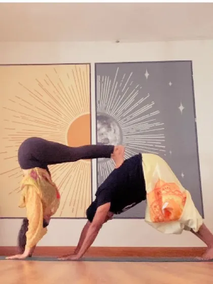 A fun partner pose combining downward dog with a handstand press. This builds trust, communication, and a lot of upper body strength.