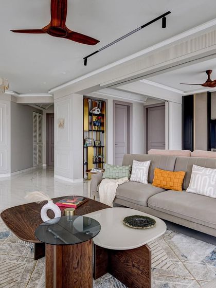 Another angle of the 'Urban Tranquility' living room, showing the flow into the entryway. The design uses consistent colors and materials to create a harmonious and expansive feel.