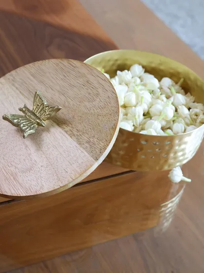 A close-up of our wooden and hammered gold keepsake box, topped with a delicate butterfly. This piece is perfect for adding a touch of nature-inspired elegance to your dresser or shelf.