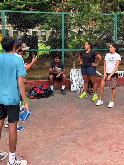 A typical moment on our court. A coach leads a group discussion, breaking down strategy and mindset. It's not just about hitting balls, it's about understanding the game.