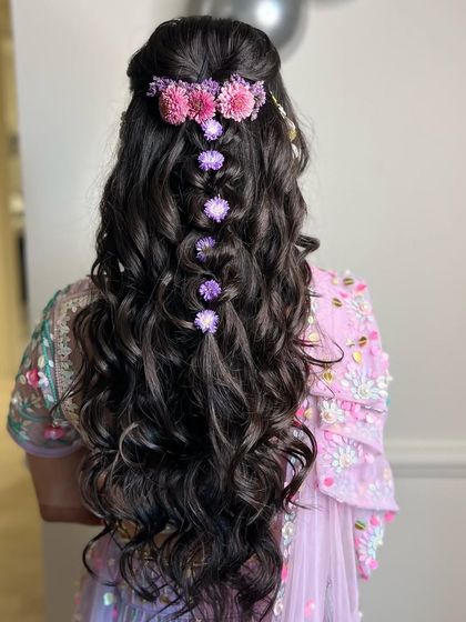 Minimal beauty at its best. A simple half-up braid adorned with a gradient of pink and purple flowers.