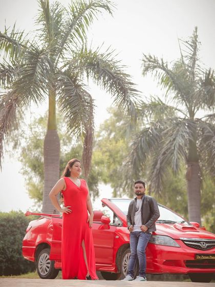 A stylish pose with a red convertible, this pre-wedding photo has a fashionable and timeless quality.
