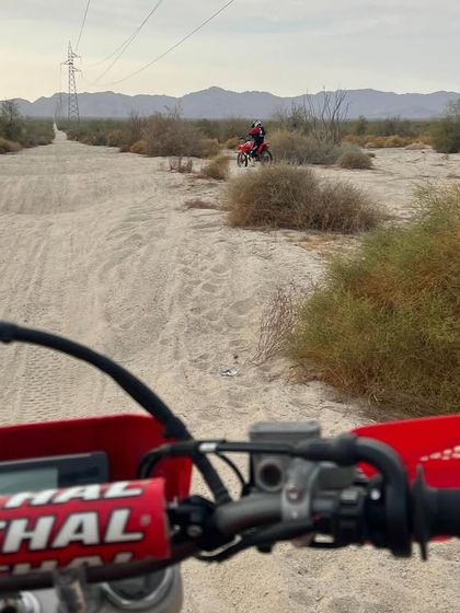 A first-person perspective during a pre-run, heading down a sandy track marked for motos and quads only. This is where we map out the fastest and safest lines.