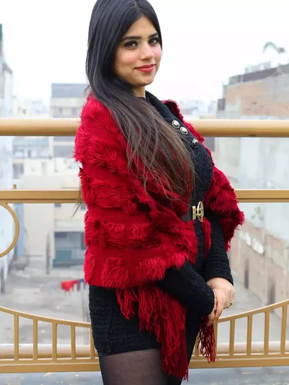 A portrait on a balcony overlooking the city. This adds an urban context to the winter series, showing a stylish look against a real-world backdrop.