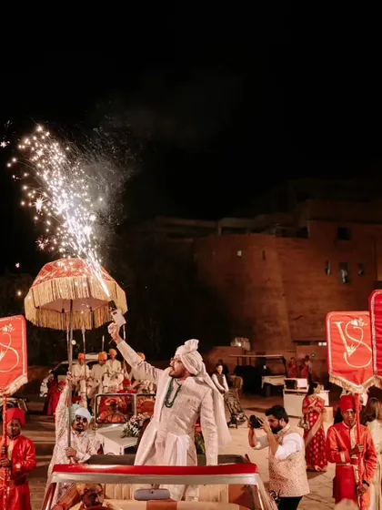A royal procession for the groom. Arriving in a vintage car with personalized banners and a champagne gun, this baraat at Suryagarh was a perfect blend of modern celebration and traditional grandeur.