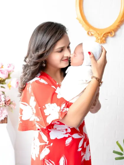 A mother's gentle love captured in a quiet moment with her newborn. This portrait focuses on the intimate connection and tenderness between mother and child in the first few days.