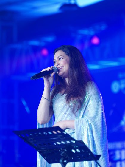 Priyanka Barve at the music stand, looking elegant and poised in the modern, glamorous saree.