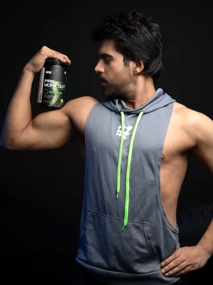 A shot focusing on the connection between the athlete and the product. The model looks at the pre-workout container while flexing, suggesting it's the source of his power. This is great for storytelling in a visual campaign.