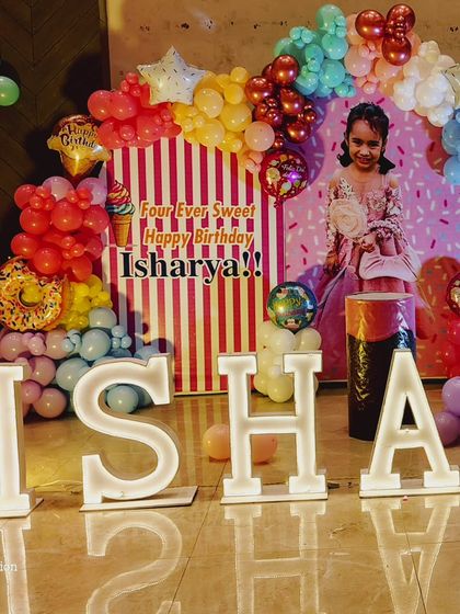 Another look at the 'Candyland' party, showing the detail of the balloon columns and the personalized 'Four Ever Sweet' backdrop.