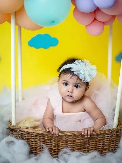 A curious look from our little traveler. The vibrant yellow background makes the pastel colors of the balloons pop in this half-birthday photoshoot.