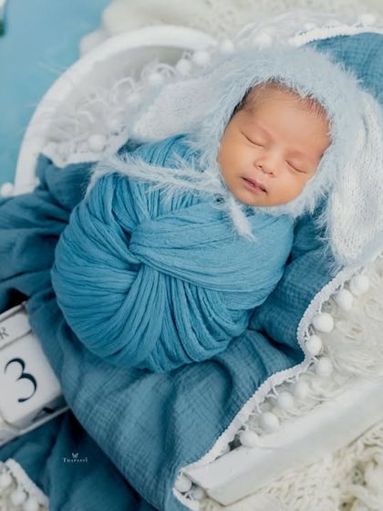 A lovely blue-themed setup for a newborn boy, complete with a date block to commemorate his arrival. The fuzzy bunny ears add an extra touch of cuteness.