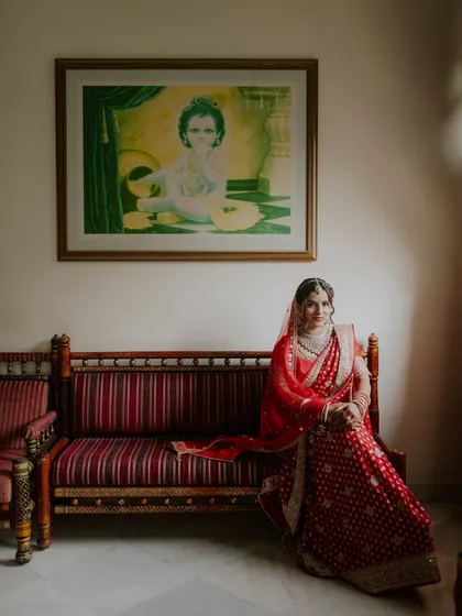 A classic bridal portrait, with the bride seated elegantly in her full wedding attire.