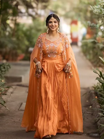 My bride Vaidehi looking radiant for her Haldi in a beautiful orange outfit. The makeup is kept fresh and glowing, with a braided hairstyle.