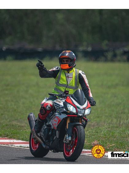 An instructor leads a group of riders on the track, guiding them through the proper lines and techniques in a real-world setting.