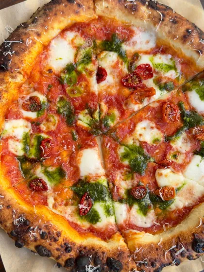 A top-down view of our Sundried Tomato & Basil pizza, sliced and ready for sharing. The colors and textures are a feast for the eyes.