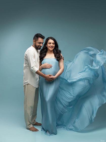 A beautiful studio portrait with the flowing blue gown. His presence adds a sense of partnership and shared joy to the image.