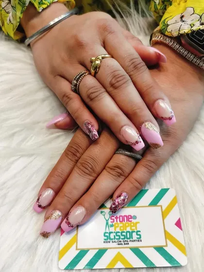 Perfect for a party or festive occasion, this design combines a soft pink base with chunky, multi-colored glitter on the tips. The mix of textures on these coffin-shaped nails adds a touch of glamour.