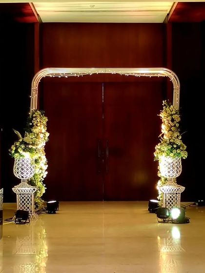 A modern and chic entrance for a Sangeet, featuring an arch of white florals. The design is clean and elegant, setting a sophisticated tone for the evening's festivities at NESCO.