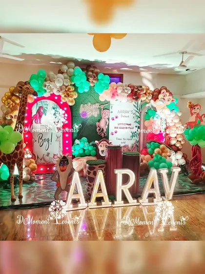 The main stage for Aarav's Lion King themed baby welcome party, featuring marquee letters, a mirrored floor, and numerous character props.