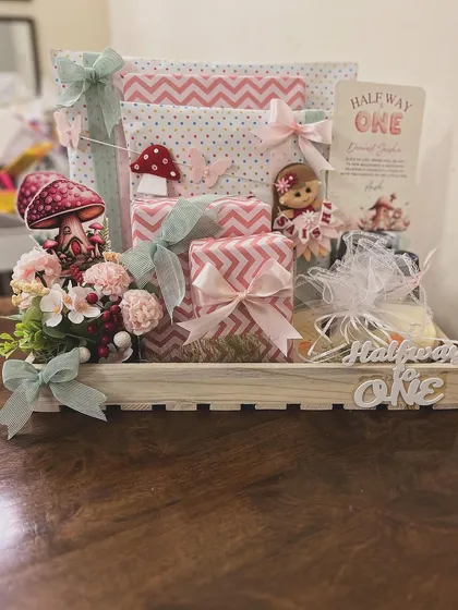 I love celebrating all the little milestones, including the quirky ones. This "Halfway to One" hamper was designed for a six-month celebration, using a whimsical fairy and mushroom theme to create a magical gift for a baby girl's special day.