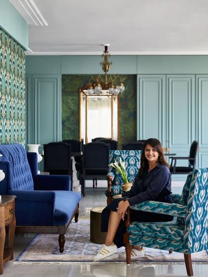 In the Bhanushali family residence, the living room is an oasis of color. Inspired by the sea, I used a striking Art Deco wallpaper and rich blue velvets to create a vibrant yet calming space for family gatherings, recycling a cherished mirror from their previous home.