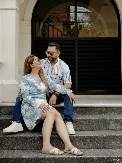 A sweet, candid moment on the steps of a building in Phuket, capturing the easy and natural interaction between the couple.
