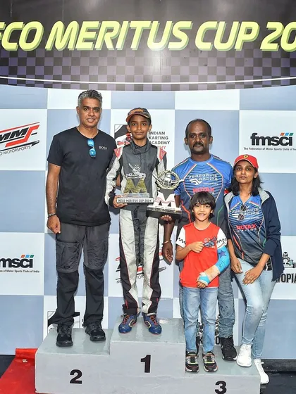 The family of a young champion celebrates on the podium at the Meco Meritus Cup 2024. We foster a community environment where families are an integral part of the racing journey.