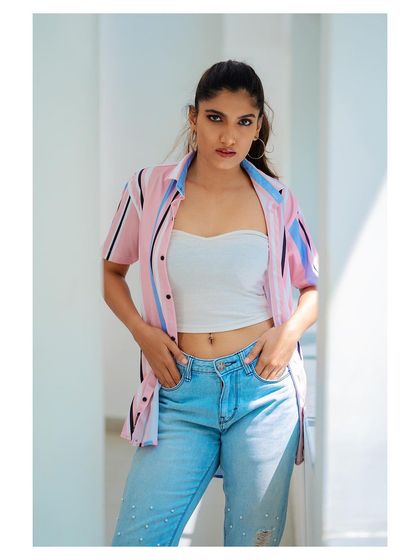 A casual outdoor portrait. The striped shirt and jeans create a relaxed, approachable look, perfect for lifestyle photography.