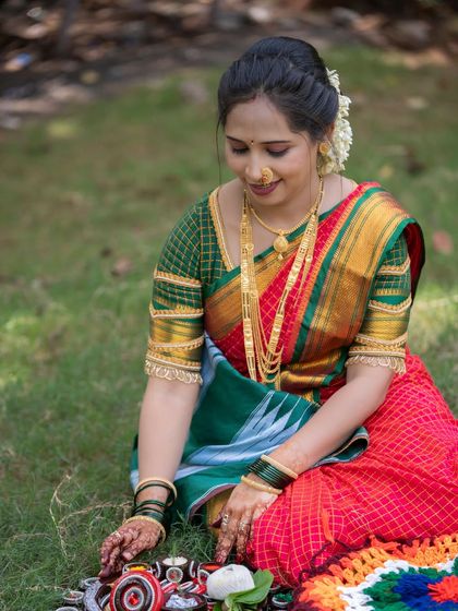 This photo shows the Vat Purnima puja setup on the grass. The woman is seen arranging the traditional items, providing a glimpse into the details of this important ritual.