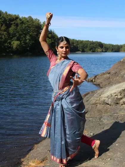 A dynamic shot from the @suta_bombay Navratri project, showcasing a strong dance pose against the backdrop of water and trees.