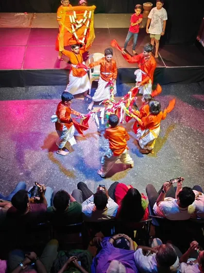 The energy is infectious! An aerial shot of a children's folk dance performance with a full and appreciative audience.