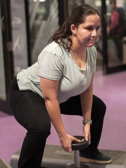 A member performs a goblet squat with a dumbbell, a great variation for maintaining an upright torso and engaging the core.