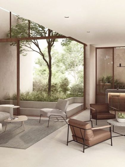 The living area for the vertical villa in 'The Nest' is organized around a double-height courtyard. This brings natural light deep into the home and creates a sense of spaciousness and connection to the outdoors, even within a multi-story building.