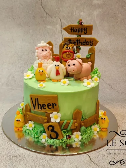 Creating cakes for kids is always special, like this adorable farm-themed birthday cake. This Chocolate Truffle cake is decorated with hand-molded fondant farm animals, including a sheep, pig, and chickens, complete with a charming wooden fence.
