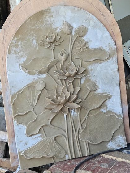 After the initial clay sculpture, a mold is made and the mural is cast in a more durable material. This image shows the raw cast of the lotus backdrop, ready for sanding, detailing, and painting.