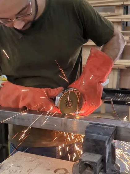 A participant carefully grinds a metal bar held in a vise. This shot shows the hands-on nature of our workshops, where you learn by doing.