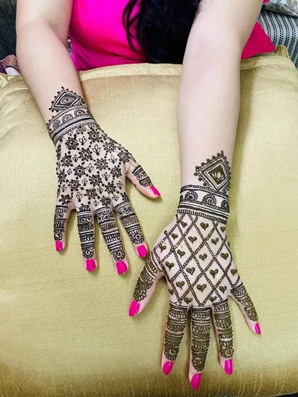 A beautiful example of two different traditional back-hand designs. One hand features a star-flower jaal, while the other has a heart-filled diamond jaal, perfect for coordinating with a friend.