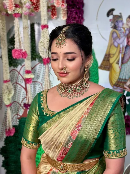 An eyes-closed shot to showcase the soft, neutral eye makeup that complements the vibrant saree.