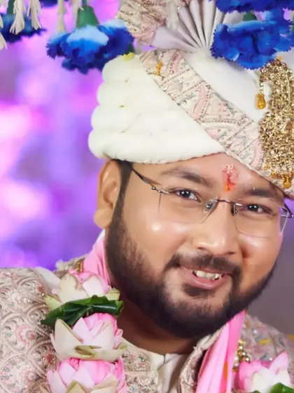 Another shot of the groom during his wedding, this time with a beautiful lotus garland. The makeup holds up perfectly, keeping him photo-ready.