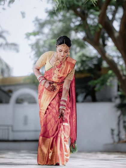 A full-length shot of the bride, capturing the graceful fall of her saree. This portrait highlights the elegance of her entire ensemble.