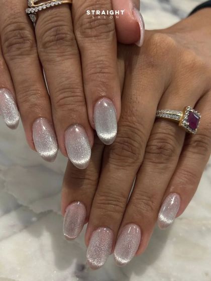The full two-hand view of the delicate silver-white cat-eye nails. The effect is clean, bright, and incredibly chic.