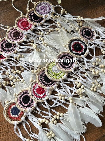 A collection of our mini cane dreamcatchers laid out, showcasing the variety of colors and patterns available. They are perfect as car charms or small wall accents.