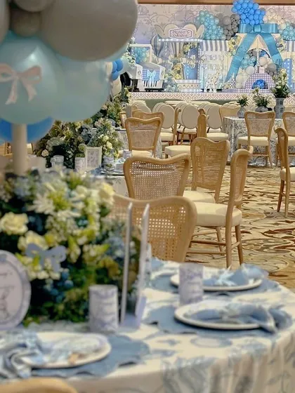 A full view of the event space, showing how the carnival theme is carried through from the grand stage to the individual table settings.