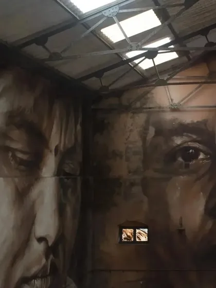Another angle of Guido Van Helten's work inside Sassoon Dock. The way the artist has incorporated the building's windows into the portraits creates a unique and haunting effect.