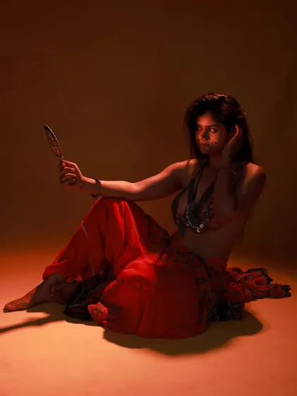 This is an example of a low-key, moody studio shoot. Using a single light source and a prop mirror, we created a mysterious and artistic portrait with deep shadows and a warm, orange glow.